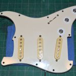 The '77 pickguard showing its age before reinstalling the knobs